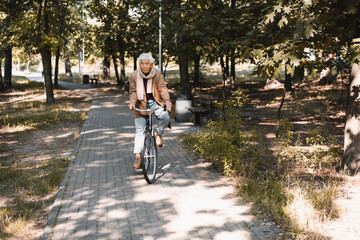 Senior asian man riding bicycle in autumn park
