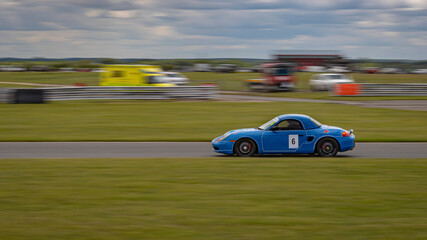 A panning shot of a racing car as it circuits a track.