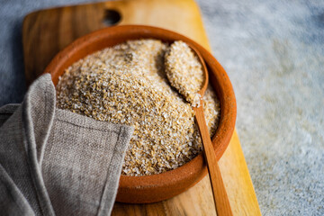 Overhead view of a bowl of milled oatmeal bran and a napkin