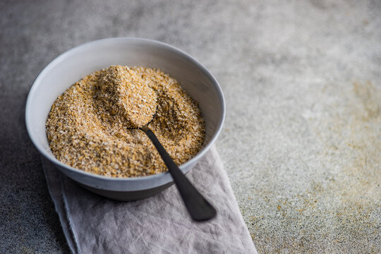 Overhead view of a bowl of milled oatmeal bran on a folded napkin