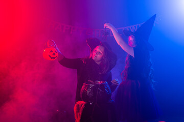 Two halloween witches making a potion and conjure in halloween night. Magic, holidays and mystic concept.