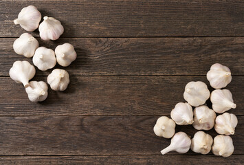 Whole garlic bulbs on a wooden table, top view.