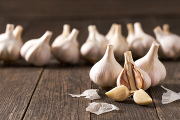 Garlic cloves and bulbs on a vintage wooden table, selective focus.