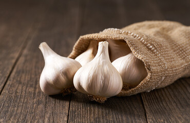 fresh garlic in a sack on a wooden table, selective focus.