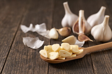 Chopped garlic in a wooden spoon on a table.