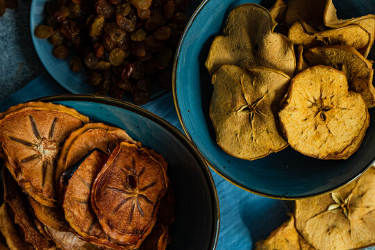 Bowls of Sliced, dried and dehydrated persimmon and apple with raisins
