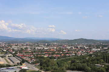Fototapeta premium aerial view of the city. Scenic view of the town in the mountains on a cloudy summer day.