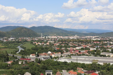 Fototapeta premium village in the mountains. Scenic view of the town in the mountains on a cloudy summer day.