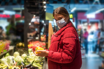 Girl wears protected mask in store. Shopping time during coronavirus outbreak. Girl in a medical mask. Quarantine and protection virus, flu, epidemic COVID-19. Coronavirus quarantine.