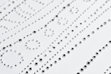 Perforated pattern on surface of paper. Close-up texture