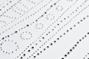 Fototapeta premium Perforated pattern on surface of paper. Close-up texture