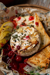 Close up of soft baked camembert head with golden crust and cherry sauce