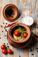 Top view of clay pot with a slow screw, lid open, wooden rustic table, spices around