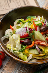 Simple vegetable salad with olives, lettuce, wooden background, top view menu photography