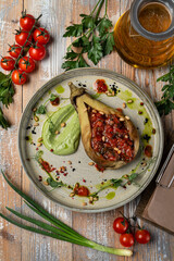 Baked and stuffed with vegetables half of eggplant on a beautiful plate, rustic-style serving, beautiful menu commercial photography