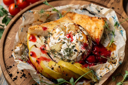 Baked and melted camembert with apple slices and toasted bread