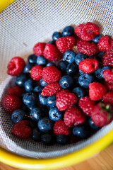Delicious juicy ripe wild berries raspberries and blueberries in colorant. Washed berries for breakfast