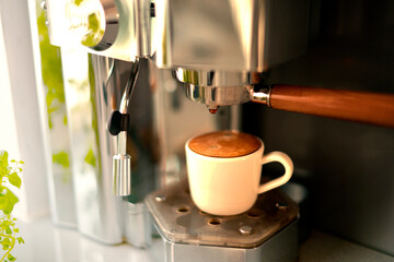 Fresh aromatic coffee a full Cup of delicious coffee in the morning in the kitchen from a home coffee machine. Morning coffee, Breakfast