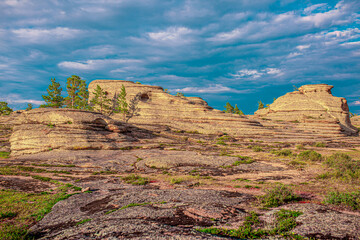 Beautiful nature of rocky mountains. Unusual landscape of nature. Trees among the rocks against the sky with clouds.