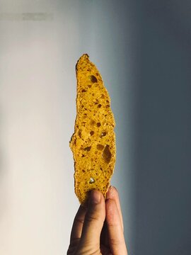 Hand holding a slice of sourdough bread