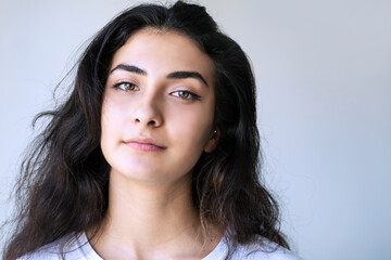young woman with a serious look on her face - gray background with copy space