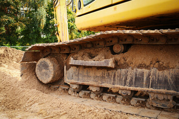 Fototapeta na wymiar Iron track yellow excavator standing on sand