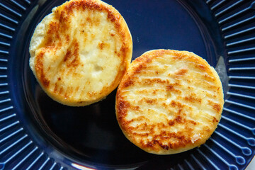Ruddy cheese cakes on a blue plate, a delicious healthy breakfast for an athlete or a child