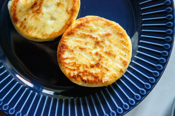 Ruddy cheese cakes on a blue plate, a delicious healthy breakfast for an athlete or a child