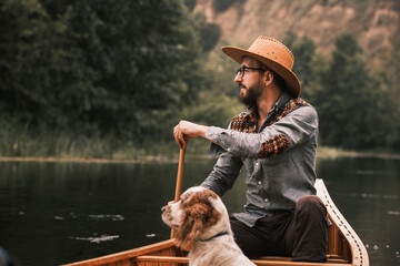 Man and dog in canoe on the river - Powered by Adobe