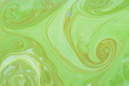 Green fluid art background. Liquid abstract pattern with UFO green. Marble texture of liquid surface. Fluid art