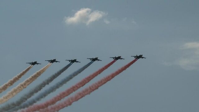 Six Sukhoi Su-25 attack aircraft (NATO, name: Frog) perform group flight. Behind airplanes are smoke in color of Russian flag. Zhukovsky, Russia, August 9, 2012.
