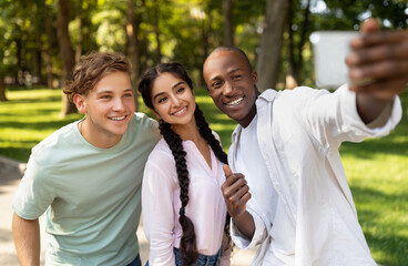 Fototapeta premium Capturing moments. Cheerful african american student guy taking selfie with his university friends in campus