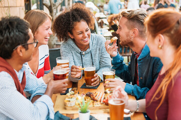 Group of diverse multi-ethnic friends having fun at a pub