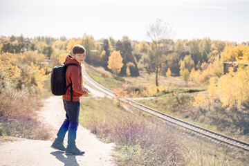 Teenager boy with backpack walking on path in autumn park. Active lifestyle, Back to school....