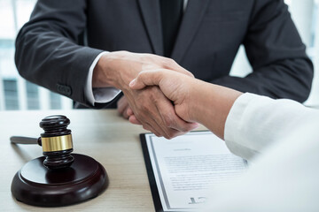 Male lawyer shaking hands with client after good deal negotiation cooperation meeting in courtroom