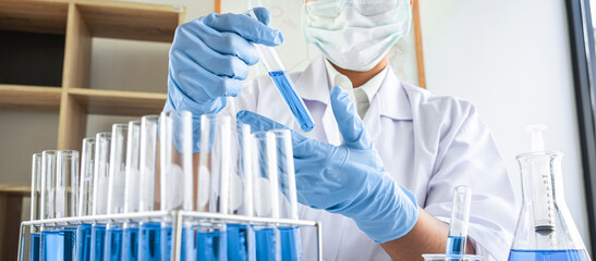 Female scientific researcher or doctor working in laboratory about virus and vaccine antiretroviral coronavirus covid19 researcher investigations with test tubes flask and blue liquid solution