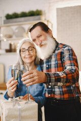 Senior couple with gifts in a kitchen