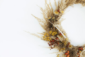 Stylish autumn rustic wreath isolated on white, close up. Creative boho wreath with dried pampas...