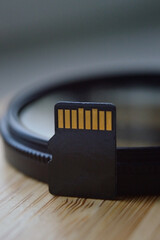 micro sd card for use in photo and video technology. micro sd lies on the lens filter. close-up.