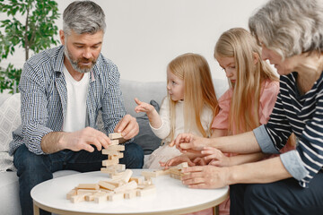 Grandparents play tower game with two girls