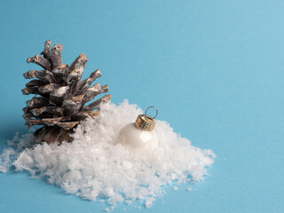 Pine cone with snow on a blue background