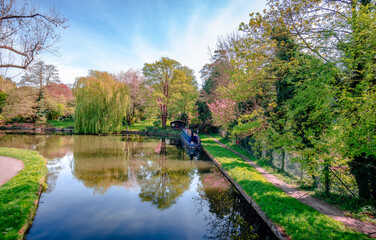 View of river Gade (part of Grand Union Canal), in Cassiobury Park, Watford, Hertfordshire, England. Reflections on water, moored narrow boat. © Apostolis Giontzis