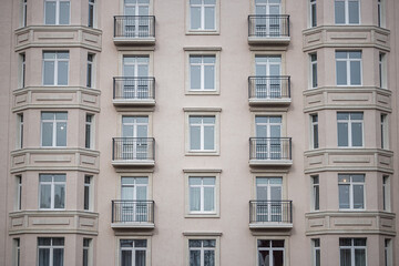 Fototapeta na wymiar Multi-storey building windows with balconies