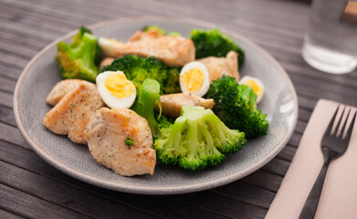 chicken breast with broccoli and quail eggs on plate for healthy dinner