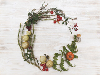 Festive autumn Thanksgiving wreath with pumpkin, fern, physalis, red berries and heather, on rustic...