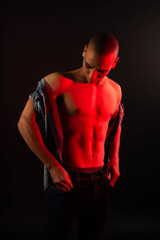 Neon light red studio close-up portrait of attractive male model portrait photo of a dark-skinned handsome guy. The muscular egyptian male on black background. Sexy naked torso. 