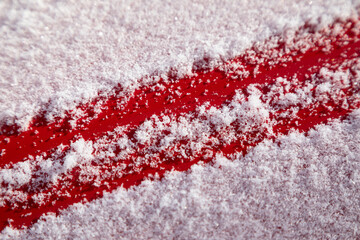Fluffy snow flakes on red metal background. Concept of first snow