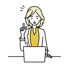 デスクで座ってPCを開いて何かひらめいたジャケットの女性