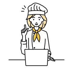 デスクで座ってPCを開いて何かひらめいた調理師の女性