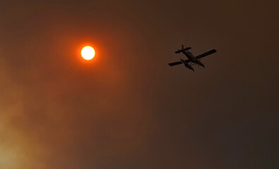 Fire plane flying into the smoke en route to a forest fire in Greece